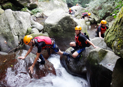 學生身著裝備，突破自我極限，挑戰攀爬十米瀑布的考驗