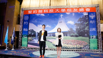2014校友年會由校友藝人王俊傑（藝名香蕉，左）及彭佳凌（右）擔任主持工作