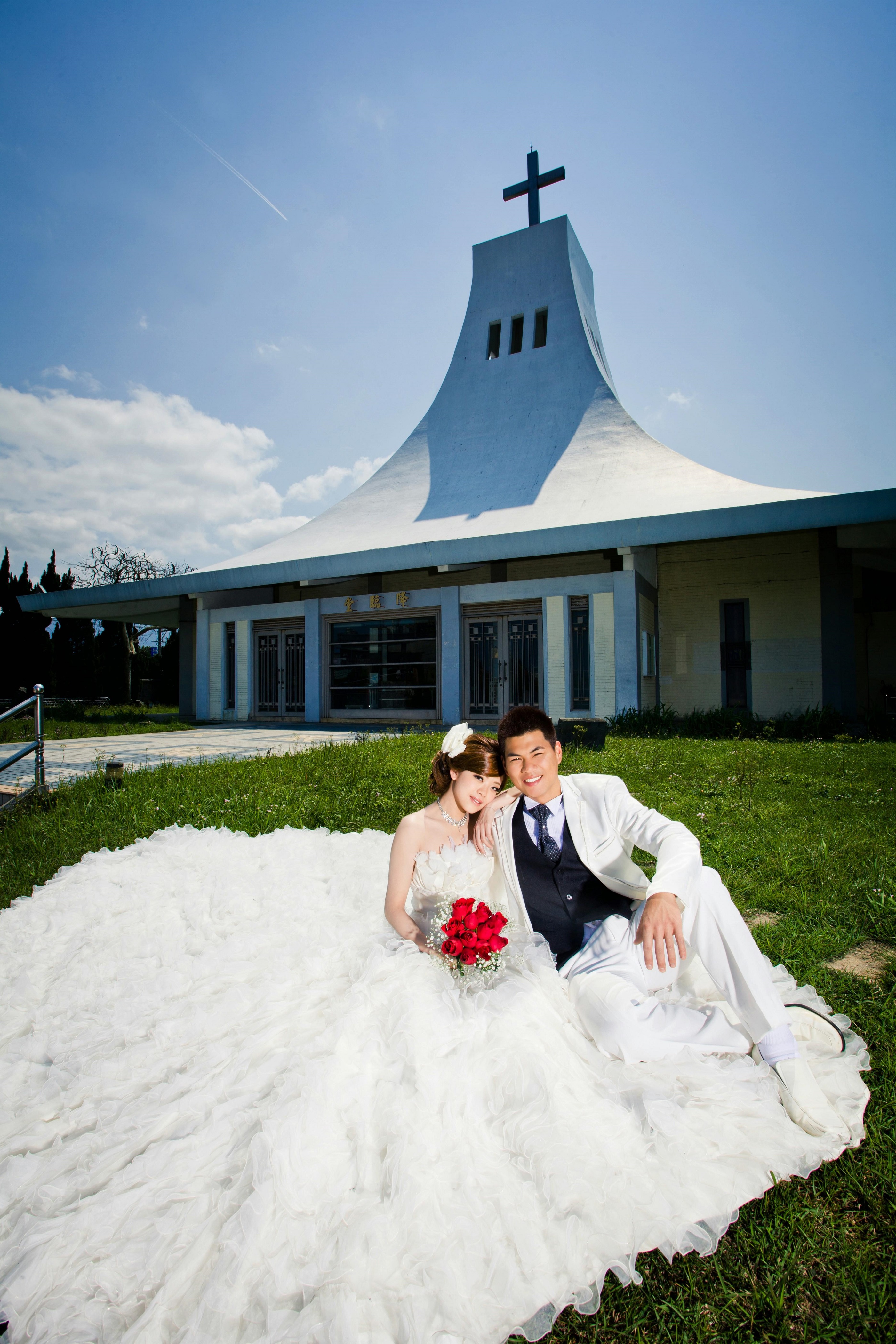 藍天白雲綠地搭配三角形雪白教堂，甜蜜浪漫的一幕，充滿幸福的氛圍
