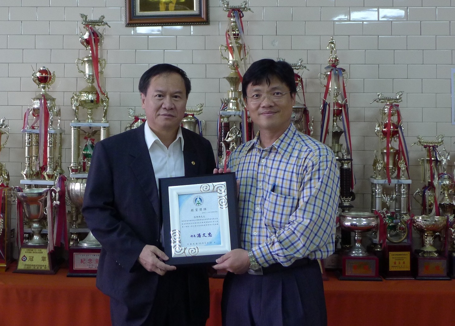 花蓮客運公司張譽興董事長（左）捐款幫助母校聖約大，艾和昌校長（右）代表教育部頒贈「捐資興學」銀質獎牌