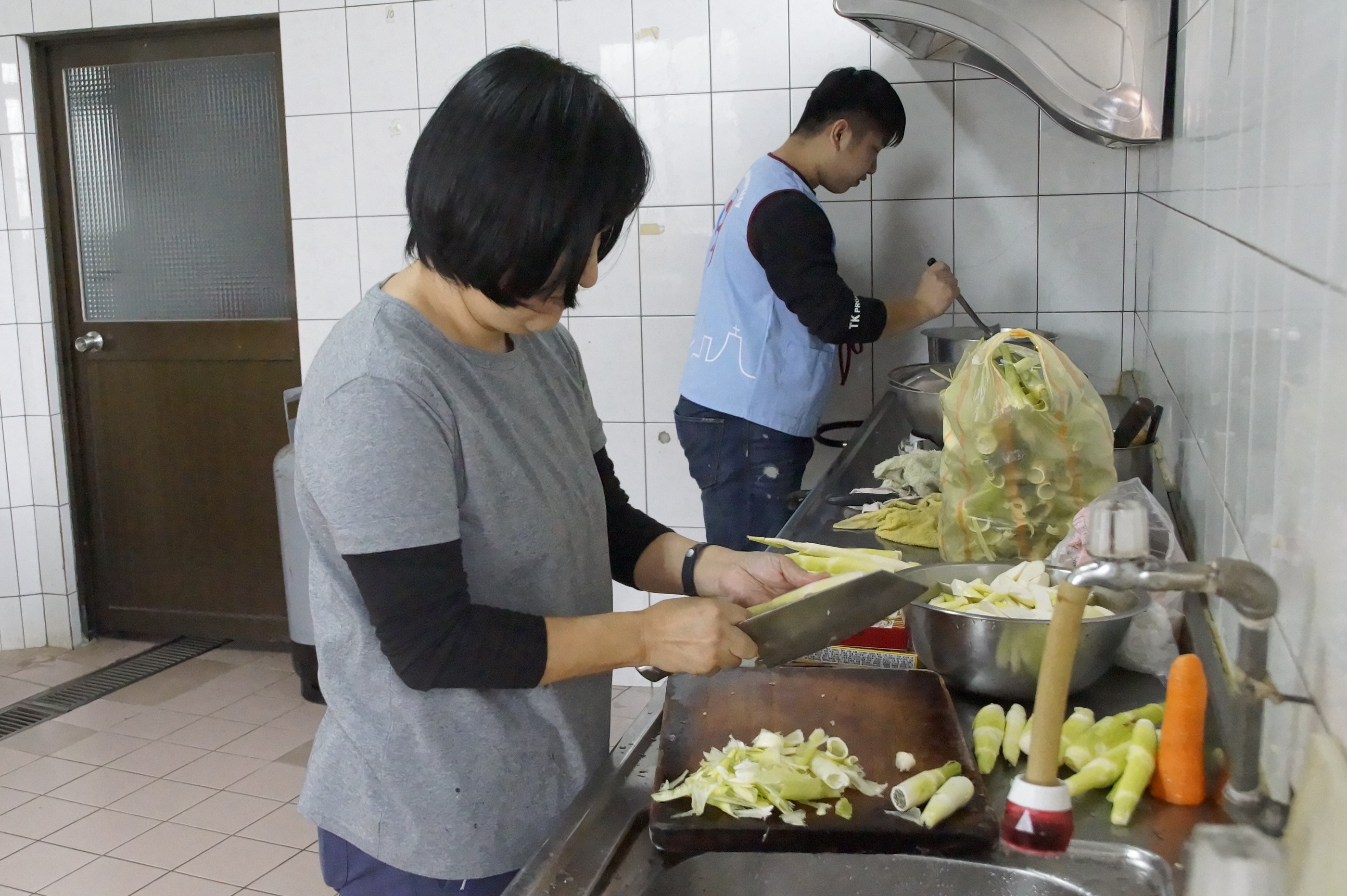 共餐活動的午餐皆由服務學習中心賈大齡主任（左）帶著服務學習學生一起準備食材及烹飪
