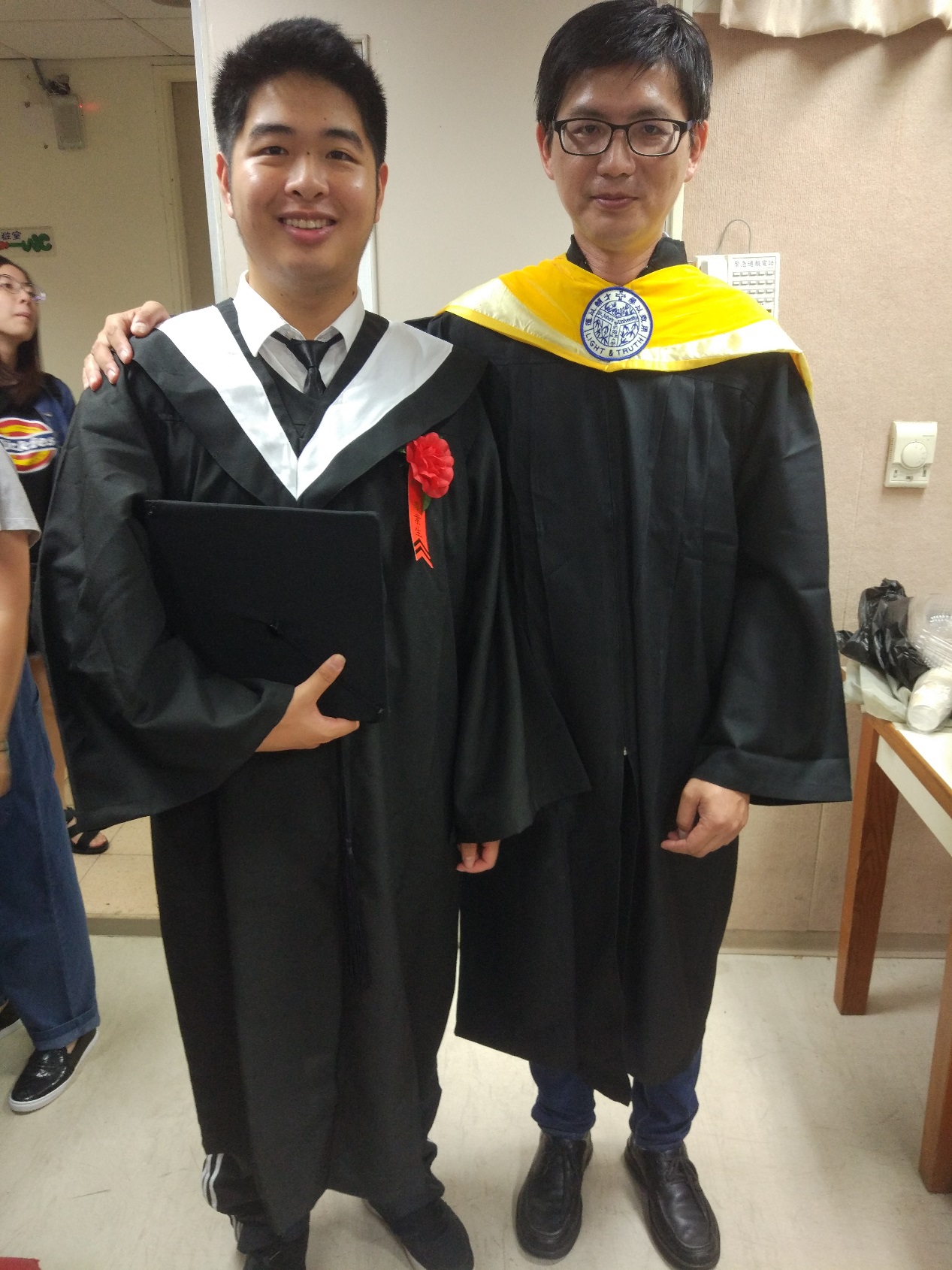 陸生陳弘毅（左）今（107）年順利完成大學學業，在畢業典禮上開心與資管系黃昭穎主任（右）合影