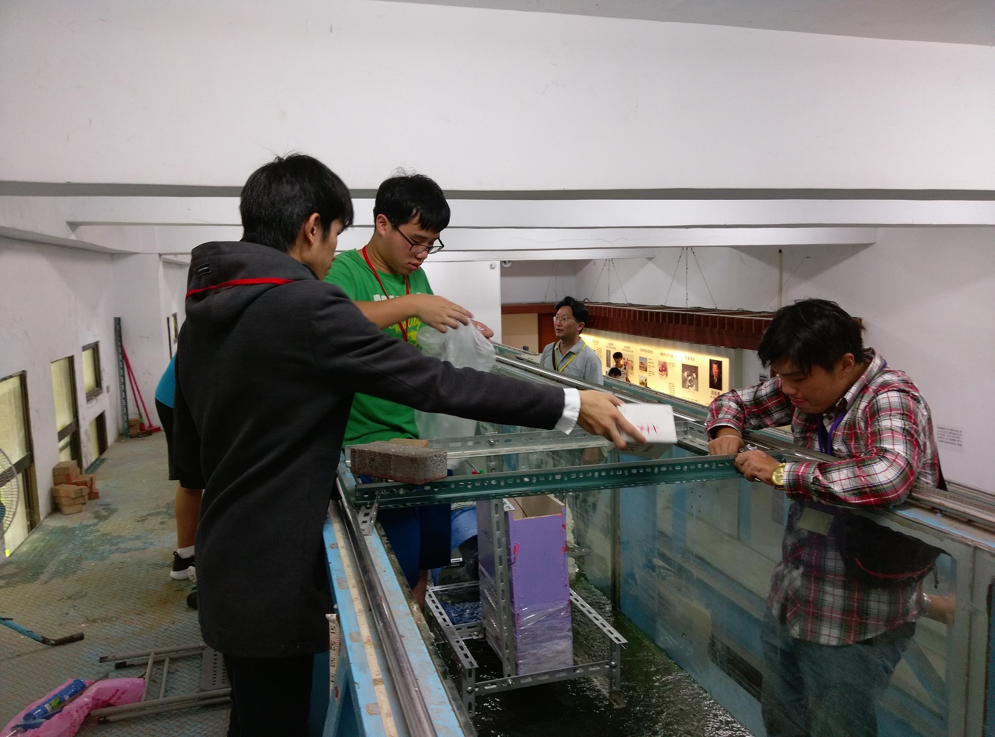 機械系同學所研發的微型水力發電機，屬於螺旋槳型水輪發電機，學生正在水工實驗所組裝及測試機組效率