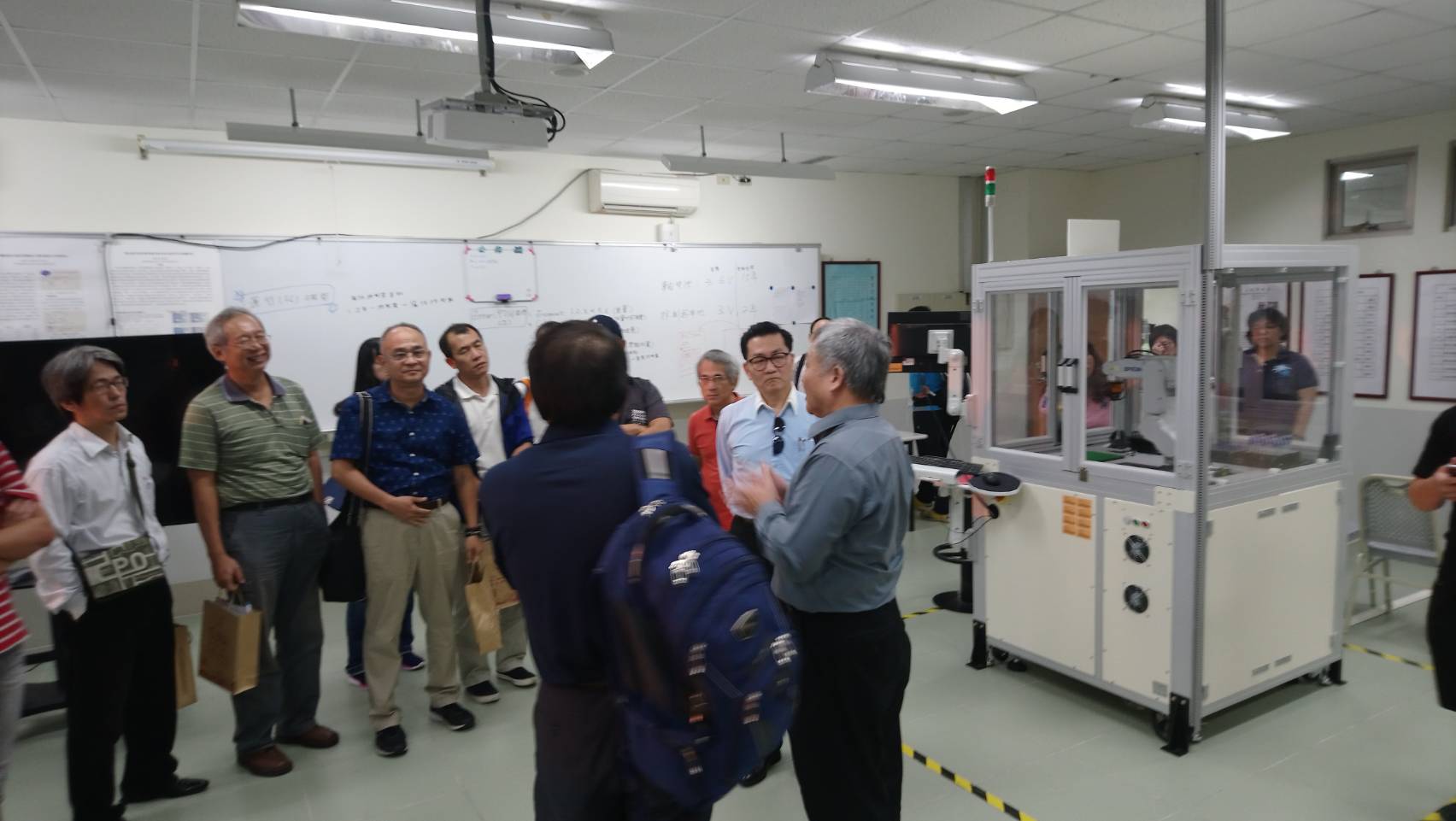 陳祖望及工程科學長參觀工管系智慧生產實驗室，對工業用機器手臂留下深刻印象。