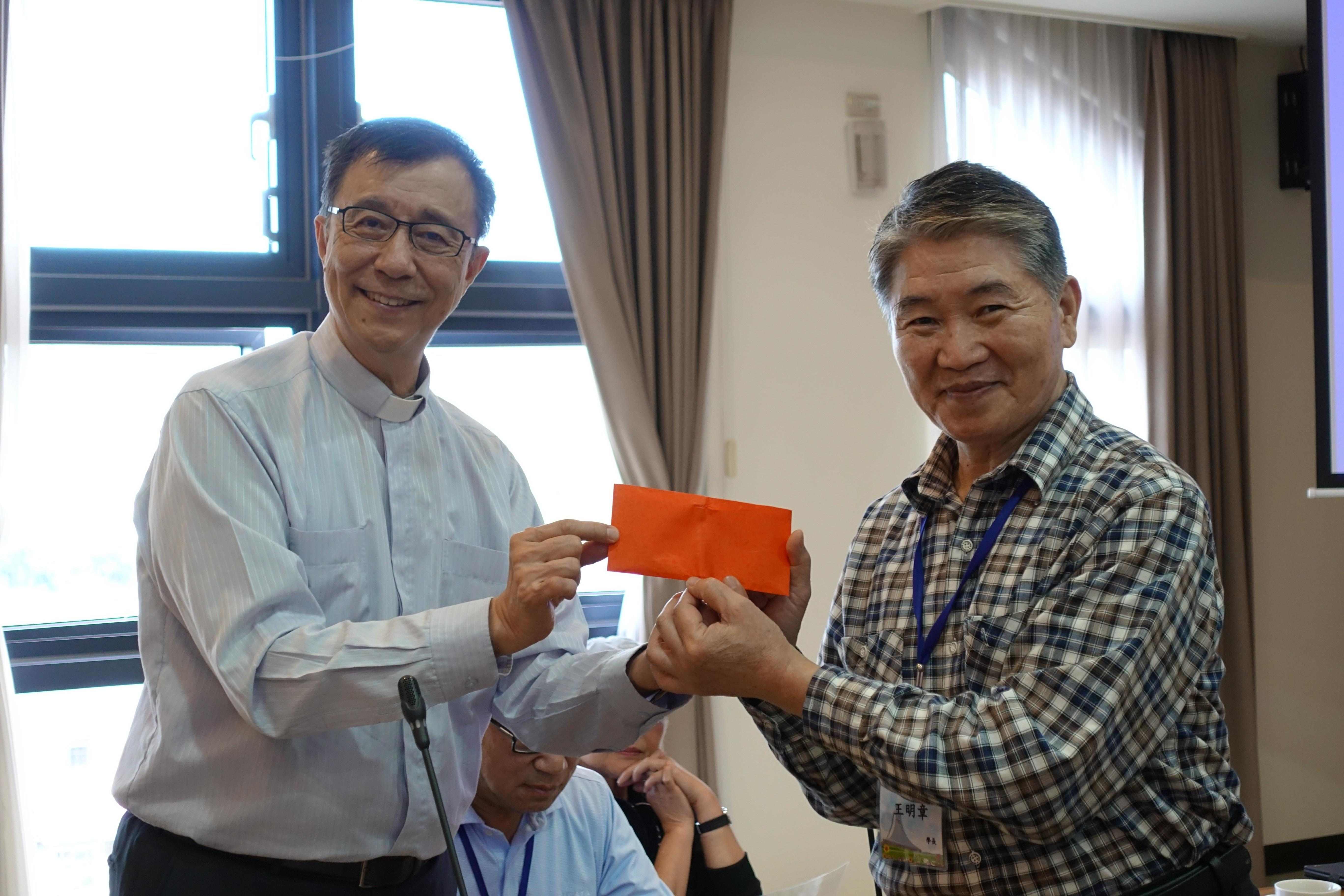 校友王明章（右）代表該班捐贈降臨堂感恩奉獻一筆，以感謝張員榮主任牧師（左）的熱忱接待。