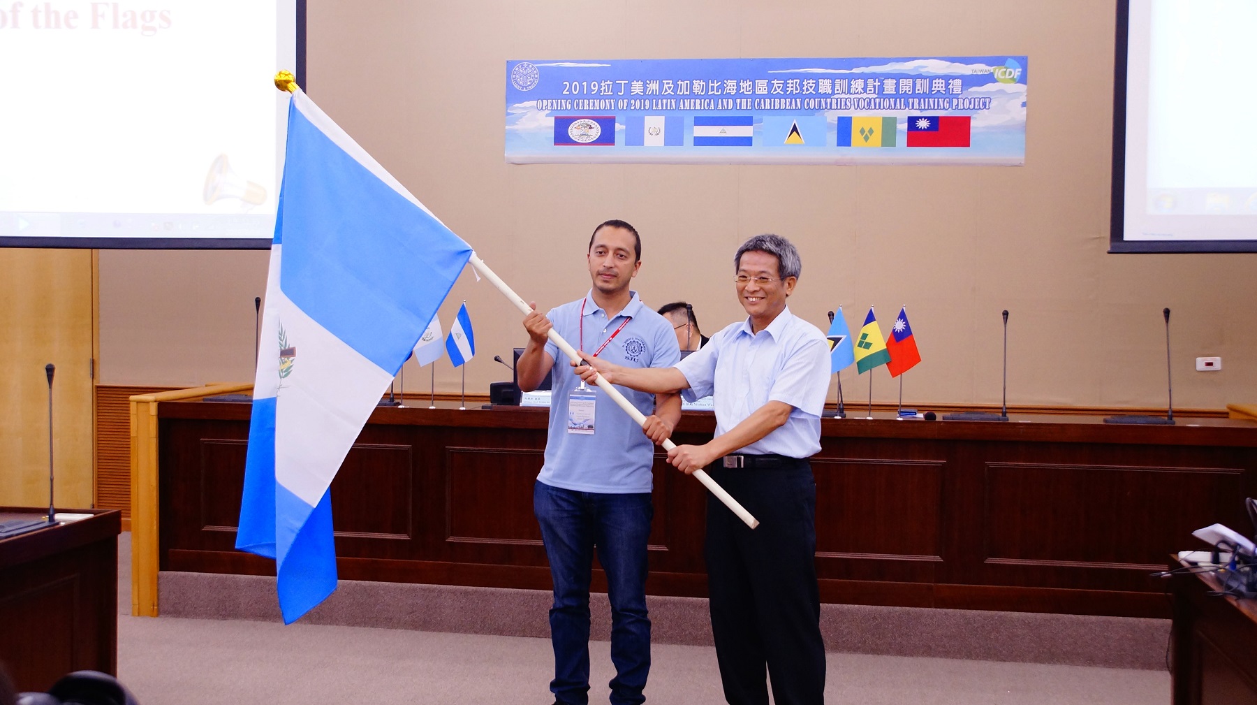 杜日富教務長（右）授旗給瓜地馬拉學員（左）