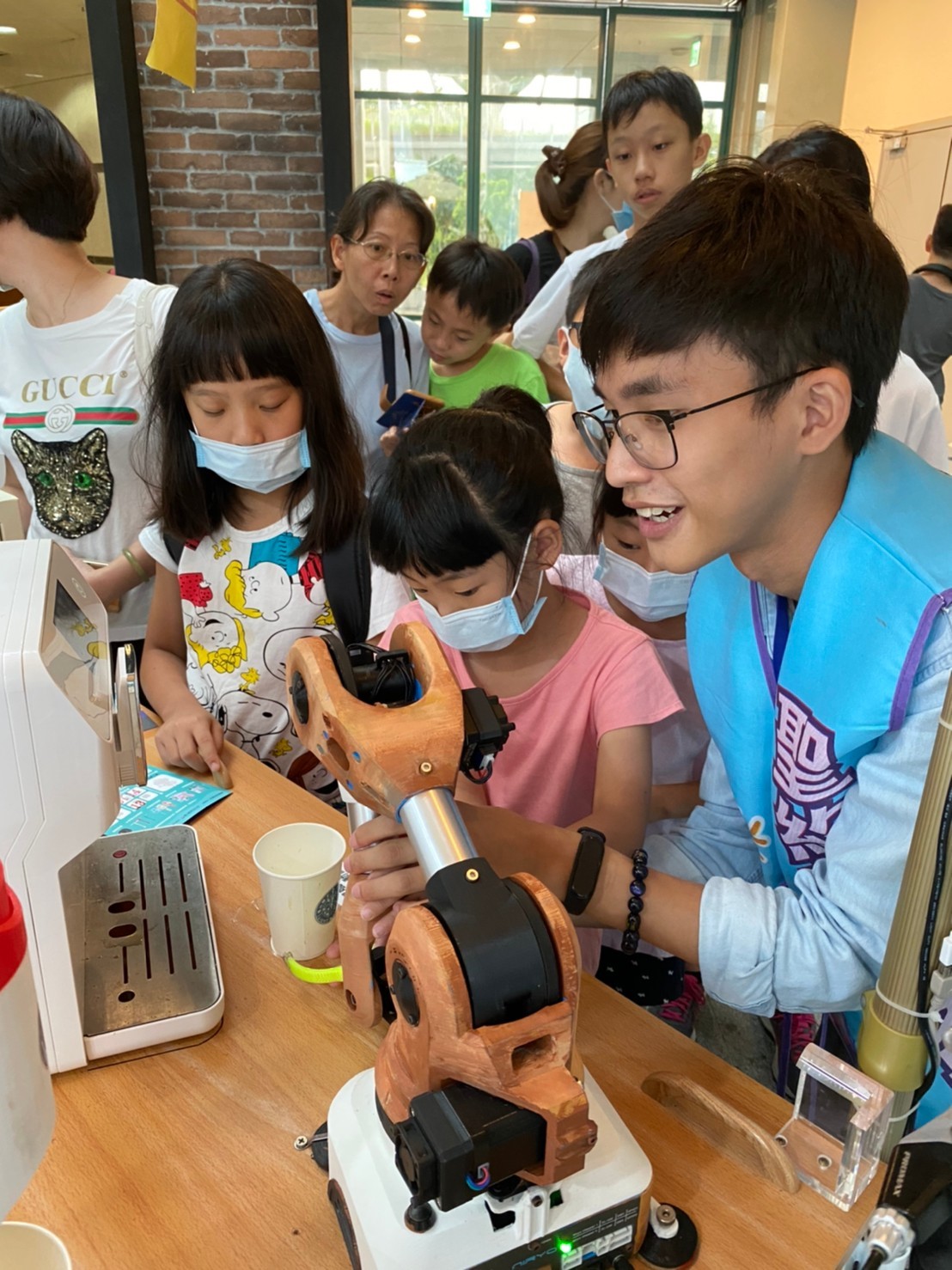 機器人咖啡餐車在展場中受到熱烈歡迎，排隊體驗的中小學生絡繹不絕。