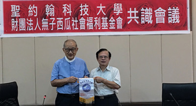 聖約翰科大黃宏斌校長（右）致贈學校錦旗給無子西瓜社會福利基金會王建煊創辦人（左）。