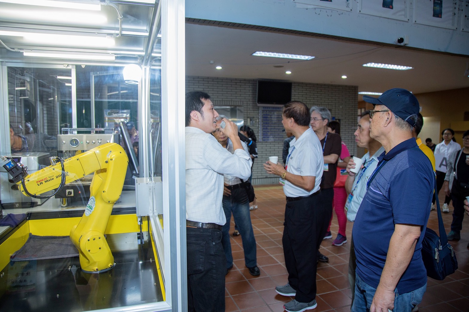 校友參觀工管系機器手臂咖啡機設備，品嚐機器人泡的咖啡。