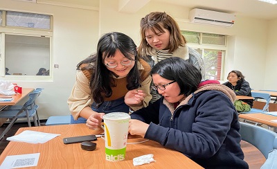 江懿庭與余玹菲同學擔任助教，與學員討論如何操作手機回收訊息。