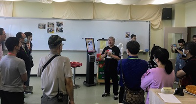 校友參觀工業管理系機器手臂咖啡機及冰淇淋機，由黃國男主任（左六）導覽解說，並品嚐美味的咖啡及冰淇淋。