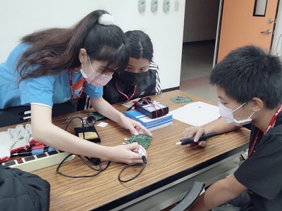 擔任技術指導的電機科邵璇同學耐心講解烙鐵技巧。