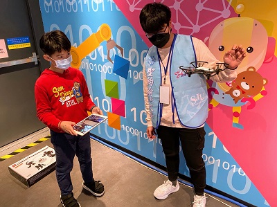 蔡尚毅同學（右）指導學童操作無人機。