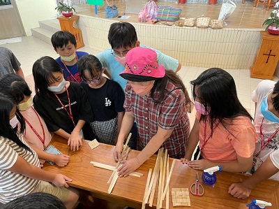 特別聘請「蘭的風工作室」潘美蘭老師（右三）蒞臨忠治教會，教導學童們認識月桃葉與學習編織的技法。