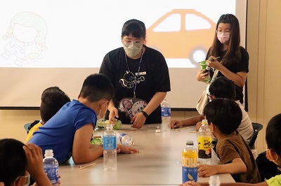 環境保育課程，輔導員指導小朋友如何利用回收寶特瓶製作動力車。