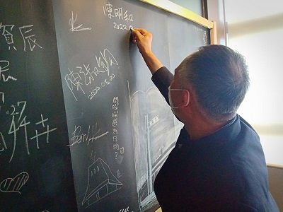 陳明和董事長在約史中心的黑板上留下簽名。