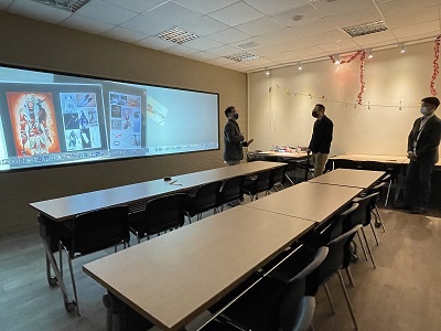 陳國雄研發長（左一）導覽解說多媒體設計系「互動媒體實驗室」的巨幅螢幕牆特色。