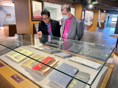 聖約翰科大董事、聖公會張員榮主教（右）陪同參訪人員參觀約翰年刊及鳳藻等約史典藏。