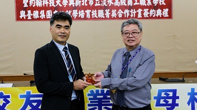 張文宇校長（右）致贈學校精神象徵降臨堂文鎮給淡水商工于賢華校長（左）。