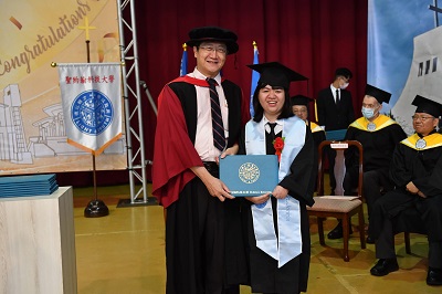 蔡路得（右）順利完成大學學業，在畢業典禮上，開心的從陳智湧教務長（左）手上領取畢業證書。